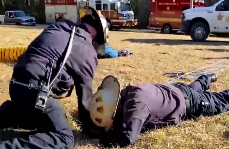 soccorritori mentre salvano gatto da fosso