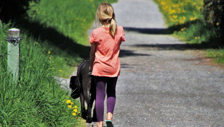 Bambina porta a spasso il cane