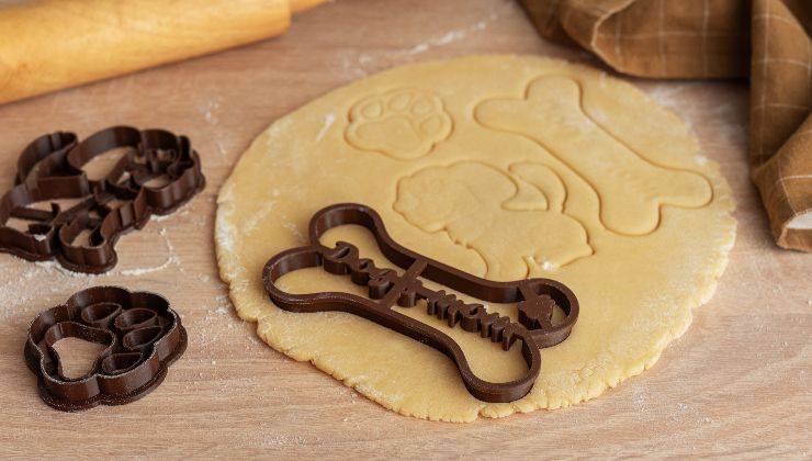Impasto dei biscotti sul tavolo con le formine per cani