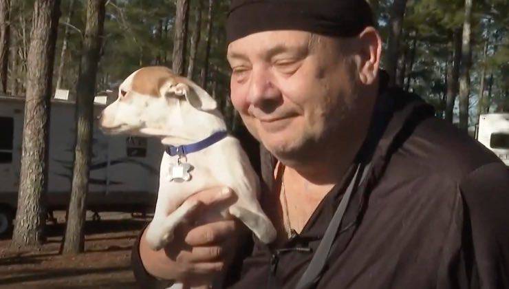 Abbraccio nella natura tra cane con disabilità e uomo in fin di vita