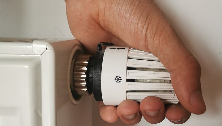 Uomo controlla la temperatura dei termosifoni