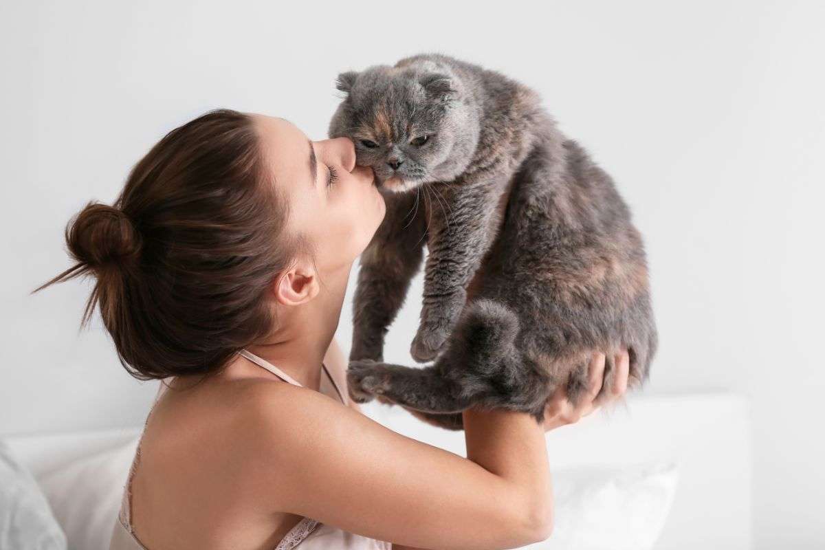 ragazza che bacia il suo gatto